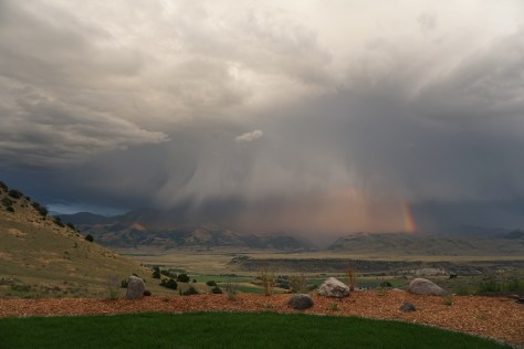 Big white clouds, rain, and a rainbow in a Montana Valley